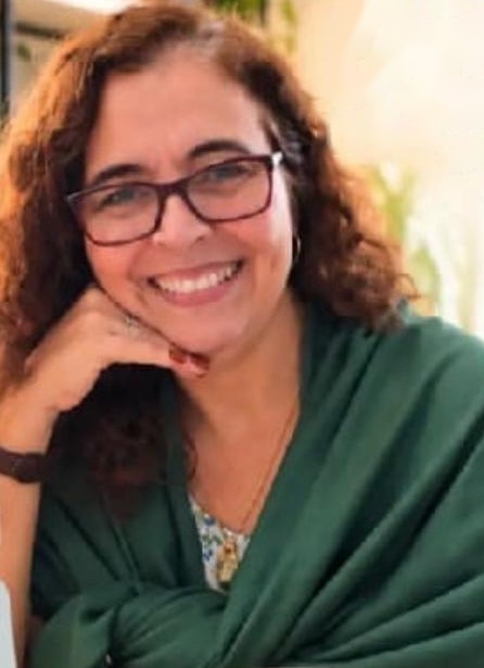 Ana Paula Vilhena, arquiteta e organizer, sorrindo com um xale verde